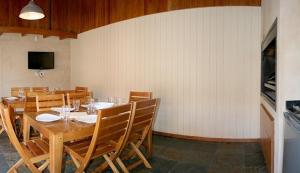 a dining room with a wooden table and chairs at Amonite Apart & Spa in San Martín de los Andes