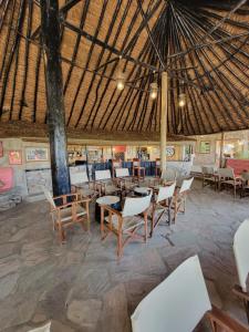 a restaurant with tables and chairs in a building at Fig Tree Camp - Maasai Mara in Talek