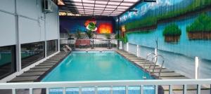 a swimming pool with a mural on the side of a building at Casa Resort in Payyannūr