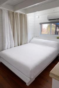 a large white bed in a room with a window at בקתות עץ סקנדינביות במטולה in Metulla
