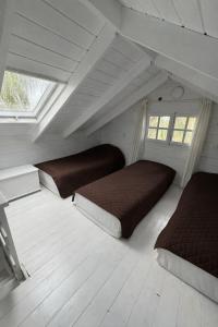 a attic bedroom with two beds and two windows at בקתות עץ סקנדינביות במטולה in Metulla
