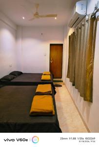 a room with three beds in it with a door at Laxmi Residency in Akalkot +7 photos