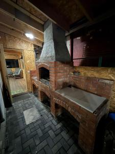 a brick oven in a room with a stone floor at White Wood Chalet in Buşteni +97 photos