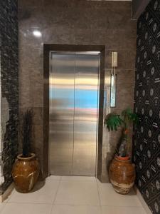 a metal elevator with two large vases next to it at Park View Stay in Male City
