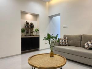 a living room with a couch and a table at Spacious Garden Home in Aurangabad +26 photos