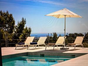 a pool with two lounge chairs and an umbrella at Villa Casiopea in Illes Balears
