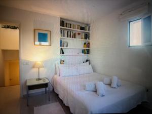 a bedroom with a white bed and a book shelf at Villa Casiopea in Illes Balears +14 photos