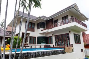 a house with a swimming pool and palm trees at Premium Villa Baan Kinlom Chomlay in Hua Hin