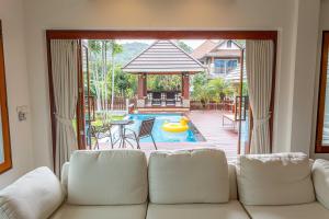 a living room with a couch and a pool at Premium Villa Baan Kinlom Chomlay in Hua Hin