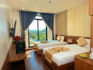 a hotel room with two beds and a large window at Tokyo Hotel Phan Rang in Thôn Mỹ Phước +76 photos