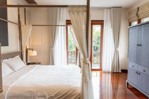 a bedroom with a canopy bed and a large window at Premium Villa Baan Kinlom Chomlay in Hua Hin +50 photos