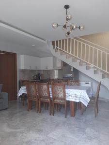 a dining room with a table and chairs and a staircase at Cozy Cottage Bakuriani in Bakuriani