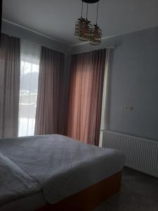 a bedroom with a bed and a large window at Cozy Cottage Bakuriani in Bakuriani