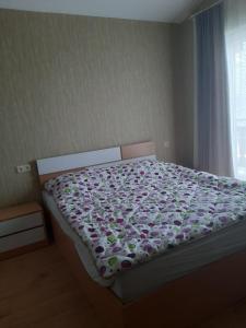 a bedroom with a bed with a flowery bedspread at Cozy Cottage Bakuriani in Bakuriani