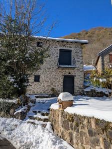 a stone house with snow on the ground at Les cimes de l'Oustal in Ax-les-Thermes