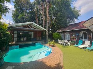 a swimming pool in a yard next to a house at African Diamond - Date Night Suite in Benoni