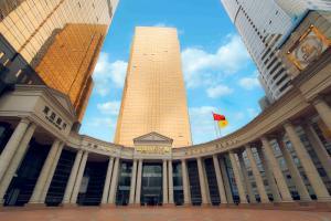 a large building with a clock tower in the middle at China Mayors Plaza - Free shuttle between hotel and Exhibition Center during Canton Fair in Guangzhou