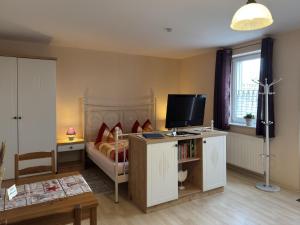 a bedroom with a bed and a television on a table at Charmante Ferienwohnung mit Garten in Wiek in Wiek auf Rügen