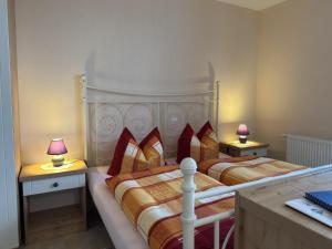 two beds in a small room with two lamps at Charmante Ferienwohnung mit Garten in Wiek in Wiek auf Rügen