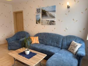 a living room with a blue couch and a table at Charmante Ferienwohnung mit Garten in Wiek in Wiek auf Rügen