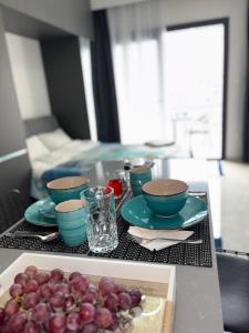 a table with bowls and plates and grapes on it at Riverside studio in Iskele in Dherinia