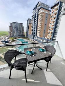 a table and chairs on a balcony with buildings at Riverside studio in Iskele in Dherinia