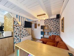 a room with a couch and a living room at Escapade marine Carnac, Petite Maison toute équipée et confortable, au calme entre plage et ville avec jardinet au sud in Carnac
