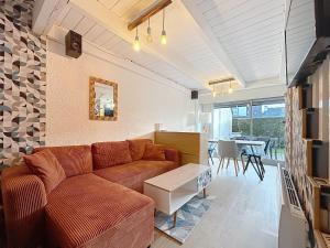 a living room with a couch and a table at Escapade marine Carnac, Petite Maison toute équipée et confortable, au calme entre plage et ville avec jardinet au sud in Carnac