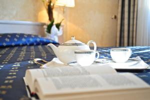 a table with two tea cups and a book on it at Sole Mare in Ventimiglia