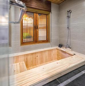 bañera de madera en una habitación con ventana en Gyeongwonjae Ambassador Incheon Associated with Accor en Incheon