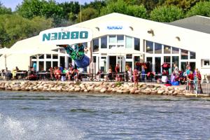a person doing a jump in the water in front of a building at Appartements im Freizeitpark Weissenhaeuser Strand in Weissenhäuser Strand