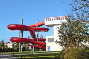 a red water slide in front of a building at Appartements im Freizeitpark Weissenhaeuser Strand in Weissenhäuser Strand