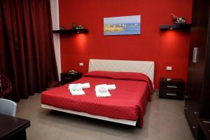 a red bedroom with a bed with towels on it at Palazzo Dei Corsari in Trapani +73 photos