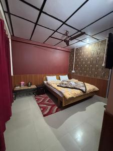 a bedroom with a bed and a red wall at Abhi house Naddi in McLeod Ganj