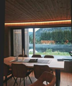 a dining room with a table and chairs and a large window at Cabin With Dock By Otra In Setesdal in Bygland