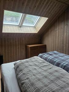 a attic bedroom with two beds and a window at Cabin With Dock By Otra In Setesdal in Bygland