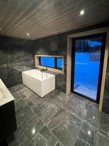 a bathroom with a sink and a large window at Cabin With Dock By Otra In Setesdal in Bygland