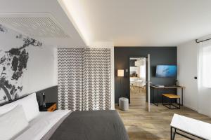 ein Schlafzimmer mit Bett, Schreibtisch und Fernseher in der Unterkunft Hotel CityMap Maribor in Maribor