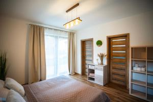 a bedroom with a bed and a sliding glass door at Apartmánový dom Budiná in Budiná