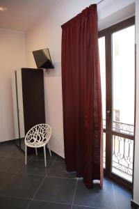 a room with a red curtain and a chair and a window at Palazzo Dei Corsari in Trapani