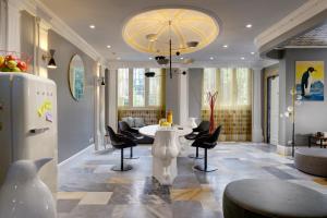 a lobby with a table and chairs and a chandelier at Residenza delle Città in Milan