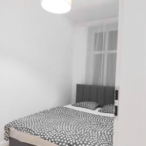 a bedroom with a bed with black and white sheets at Klonowicza UP in Leszno