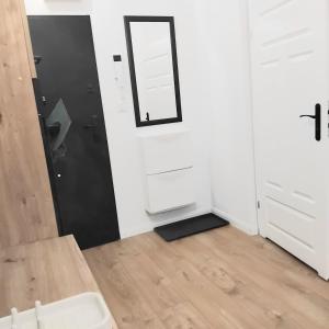 a bathroom with white cabinets and a mirror at Klonowicza UP in Leszno