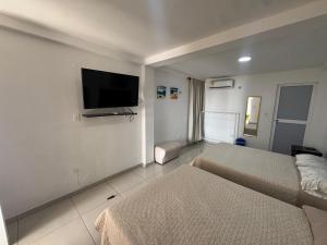 a hotel room with two beds and a flat screen tv at Apartamentos Sound Bay Beach in San Andrés