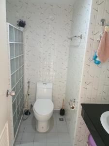 a white bathroom with a toilet and a sink at VIP condochain 24th floor in Ban Phe