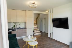 a kitchen and living room with a table and a tv at Sani Beverly Hills Luxury Villas in Sani Beach