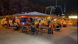 a group of people sitting at tables under an umbrella at Appartment floor 1 in Thun