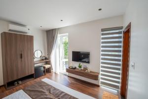 a living room with a flat screen tv on a wall at Kim Luông Homestay in Thôn An Hòa