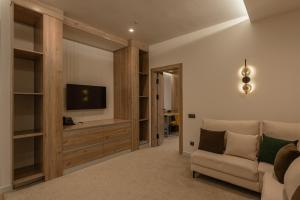 a living room with a couch and a television at Apart Hotel Istaravshan in Tashkent