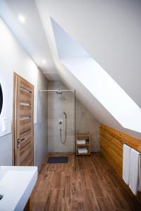 a bathroom with a shower in a attic at Apartmánový dom Budiná in Budiná +39 photos